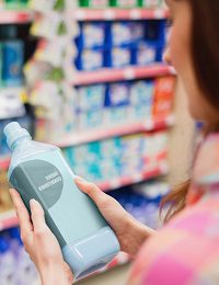 Shopper examining cleaning product in supermarket