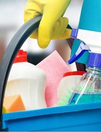 Gloved hand holding cleaning products