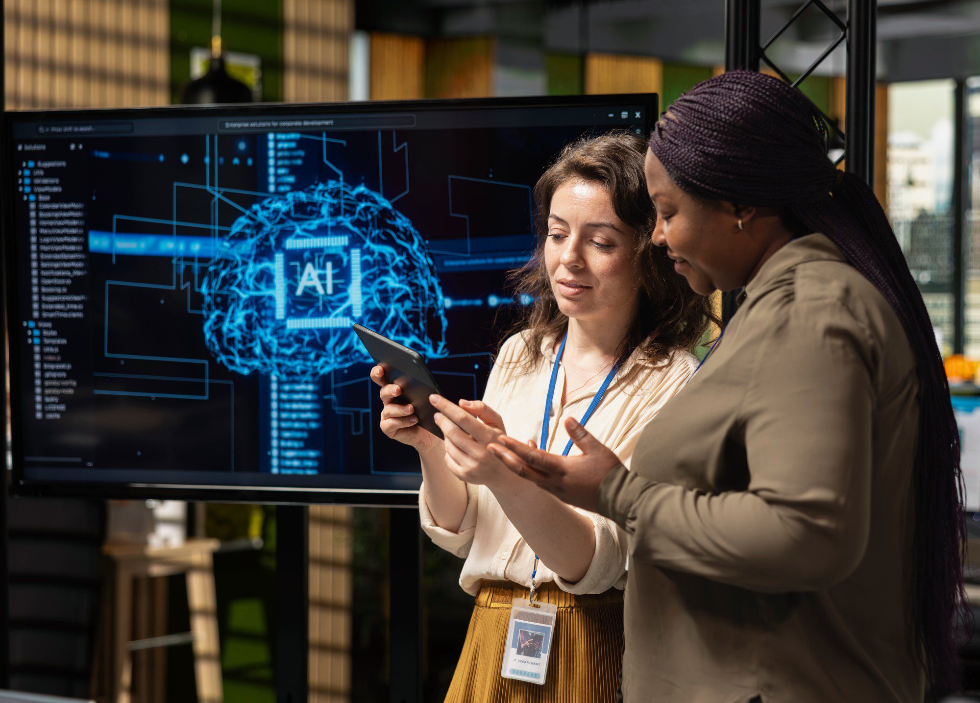 Women discussing technology in office