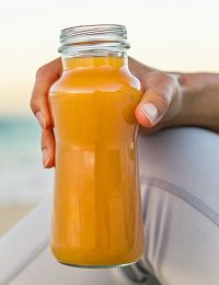 Person holding refreshing orange drink
