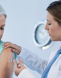 Woman receiving vaccination from doctor