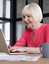 Senior woman typing on a laptop
