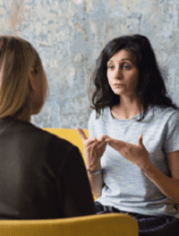 Intense conversation between two seated women.