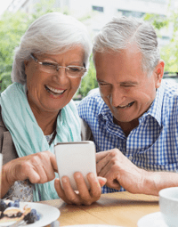 Happy older couple using phone