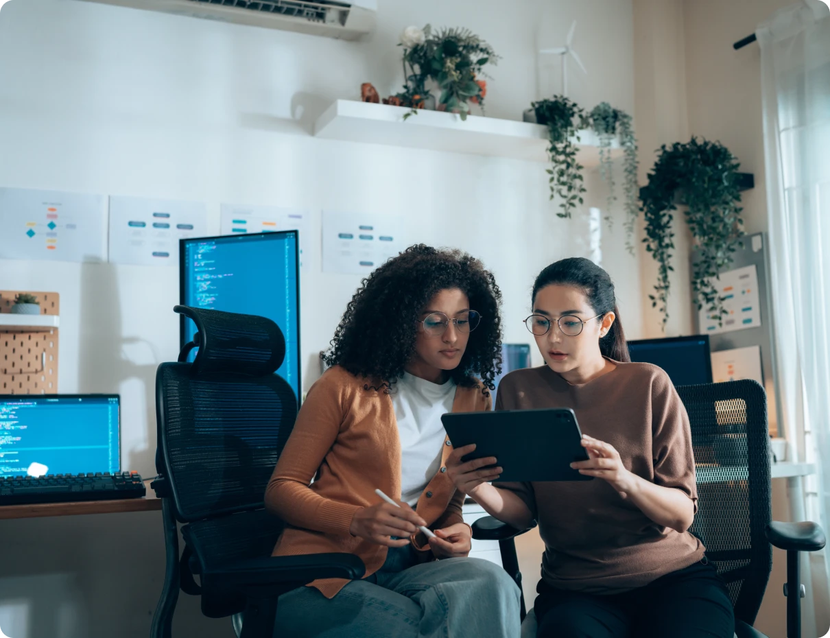 Women collaborating on a tablet in office
