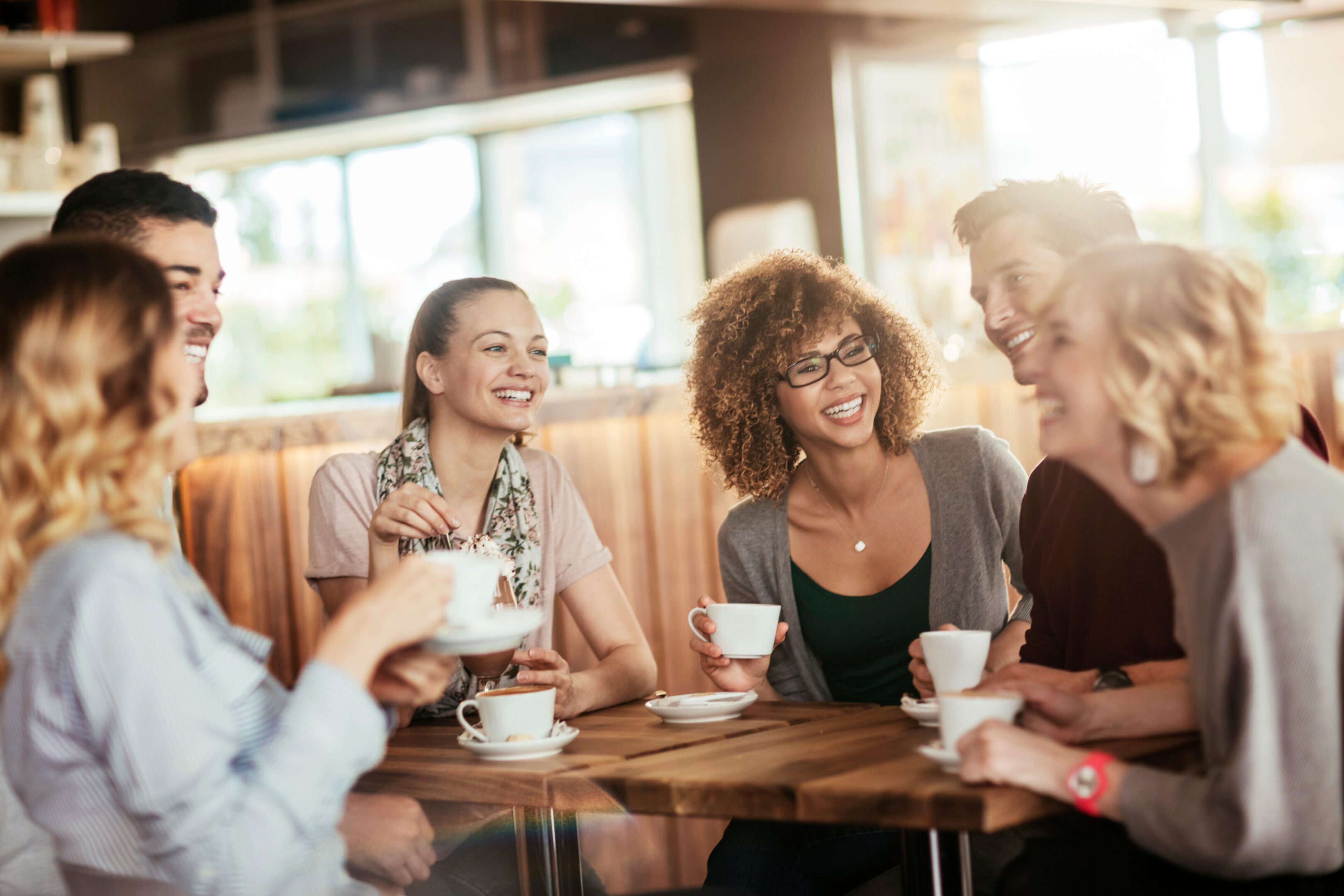 Young and diverse group of people having coffee together at a cafe in the city