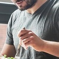 Person eating salad with fork