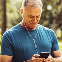 Man in blue shirt using smartphone outdoors