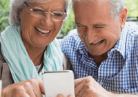 Happy older couple using phone